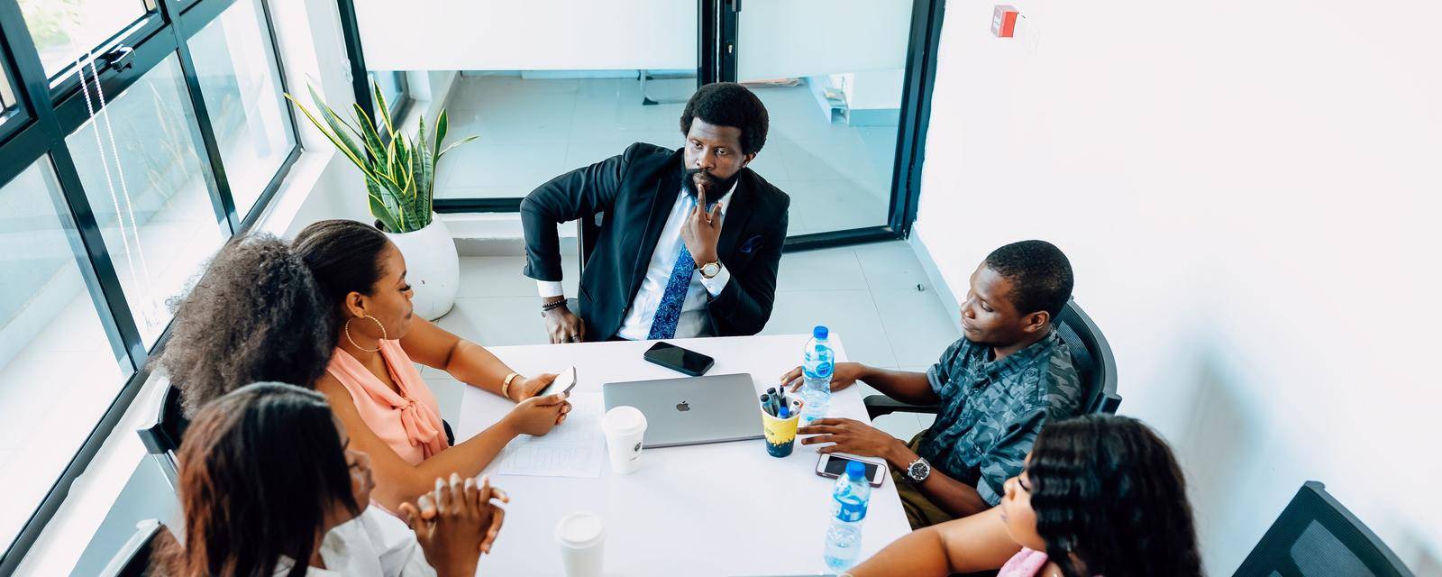 Colleagues in discussion around a table in a daylit Lagos office
